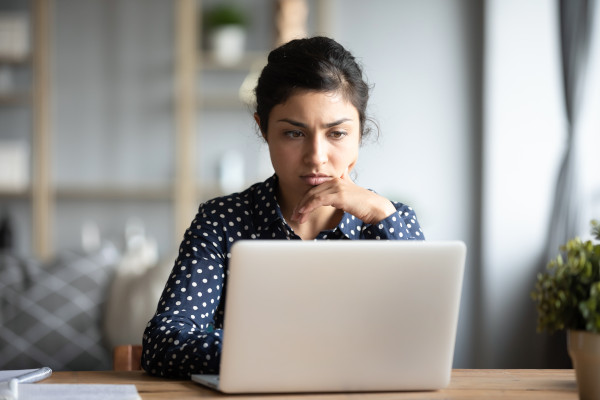 Woman at a computer looking puzzled